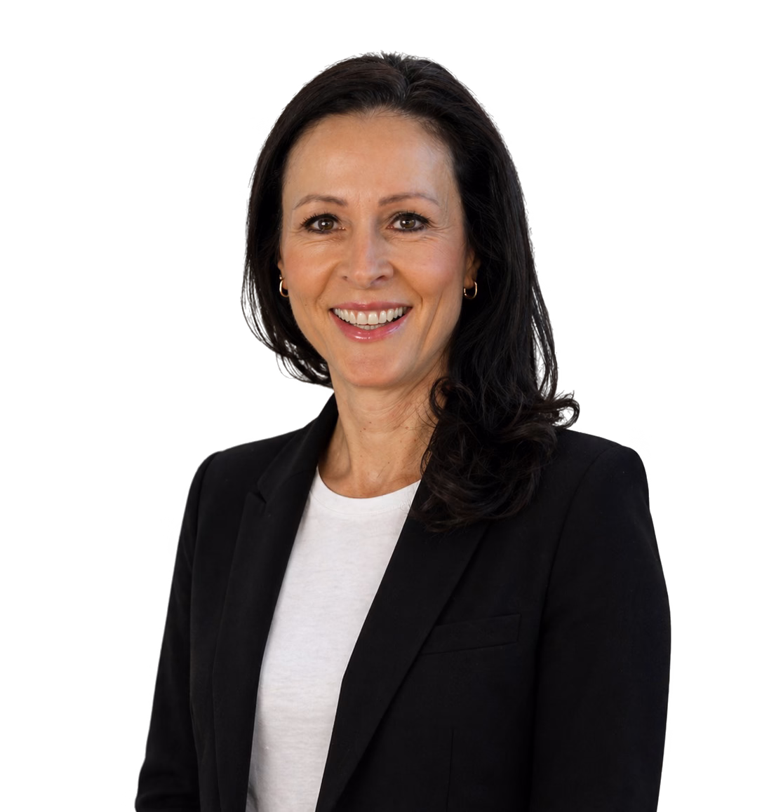 Ansprechpartner; Eine Frau mit langen dunklen Haaren, die einen schwarzen Blazer über einem weißen Hemd trägt, lächelt in die Kamera.